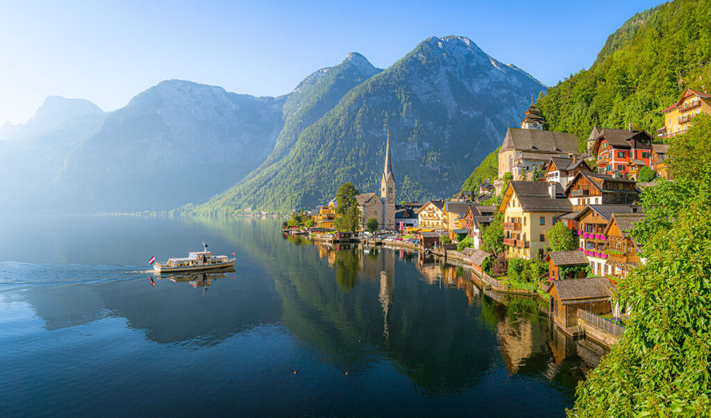 beautiful view of hallstatt with ship at sunrise, salzkammergut,